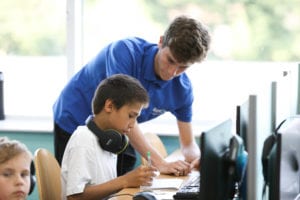 Tutor helping student on computer