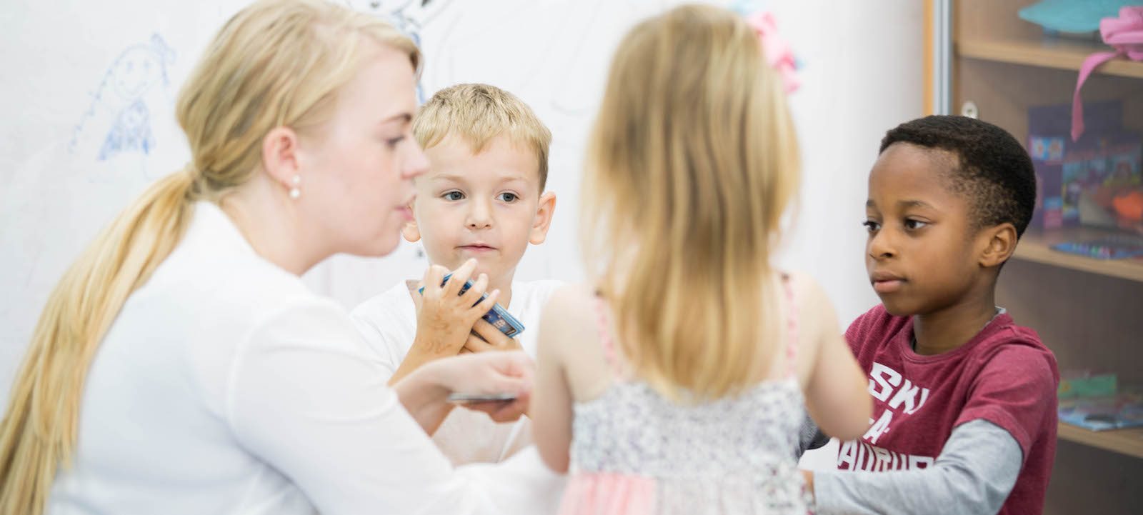 Learning with a disability - three children playing with female tutor