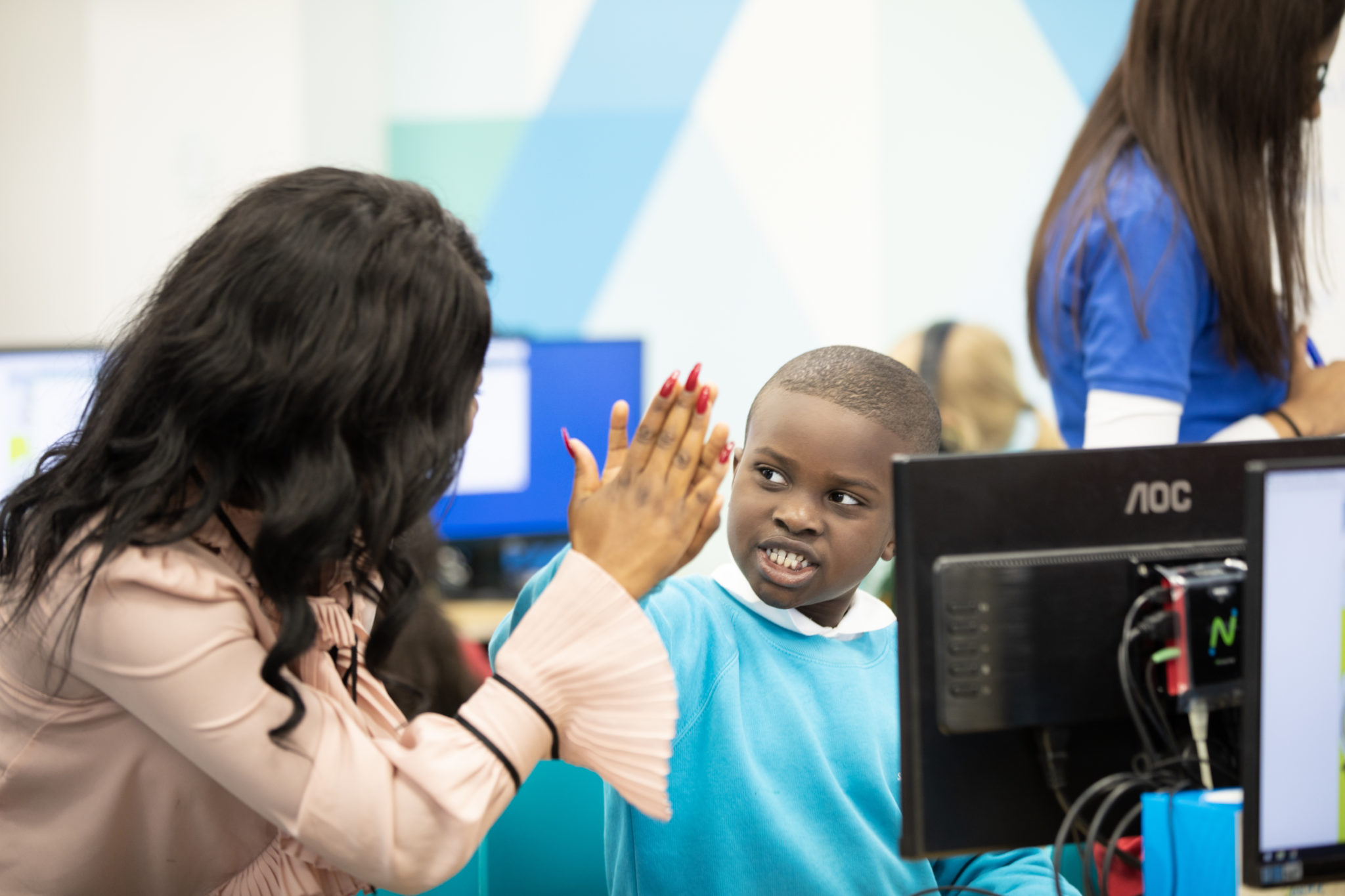 Tutor high fiving reception year student
