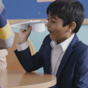 Student holding paper aeroplane