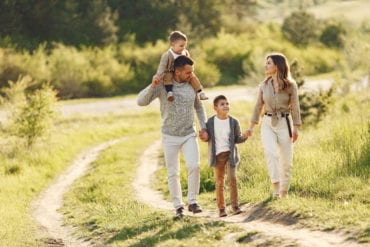 Family walking in a field in the summer time