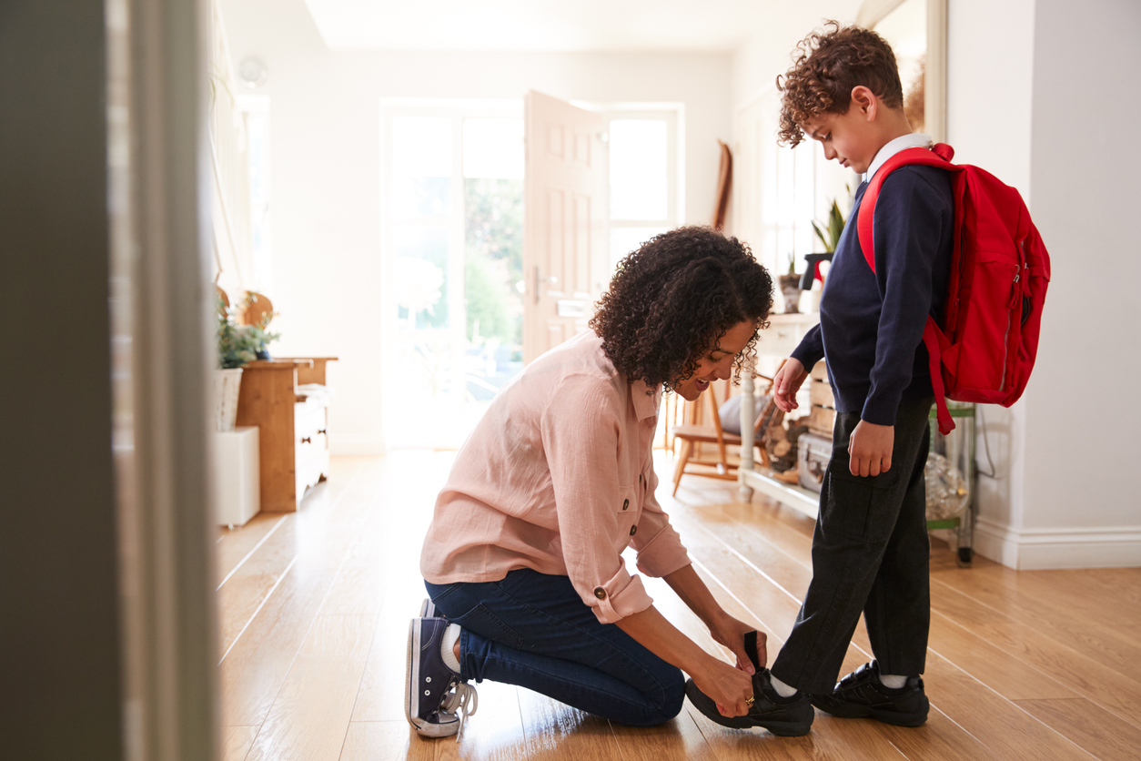 Mother helping boy get ready for the first day back to school