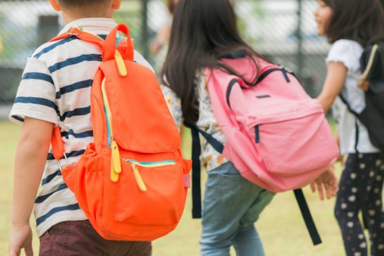 Children wearing backpacks in the playground