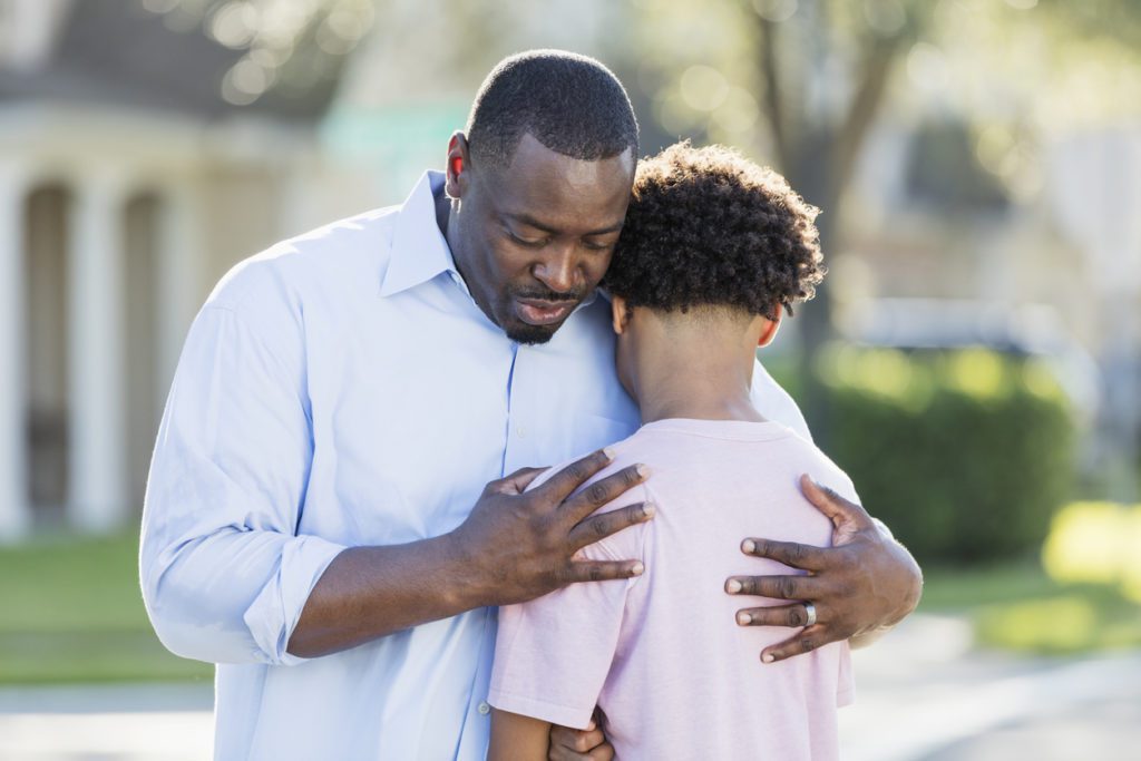 Father comforting son after being bullied
