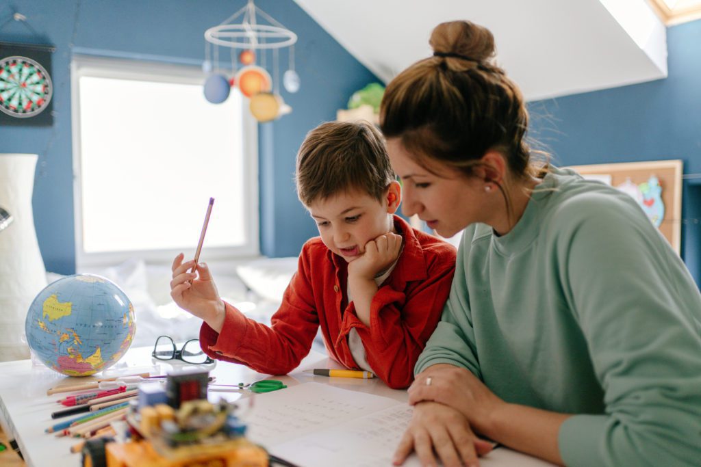 Woman and child work on homework in a child's bedroom