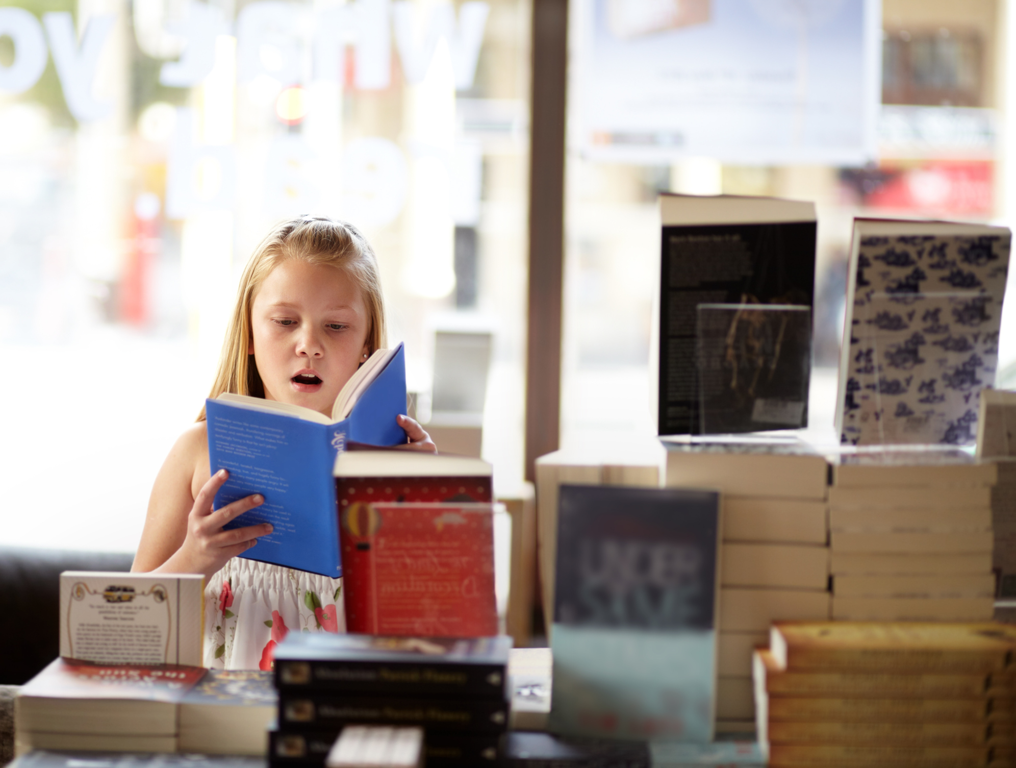 A young girl reading in a bookshop